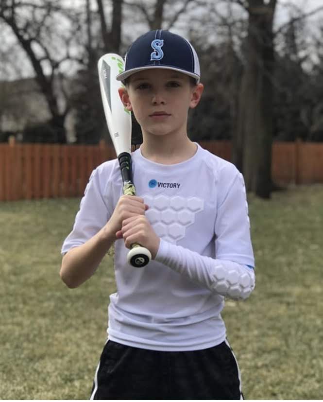 Baseball player with youth baseball and softball protective compression shirt white front view