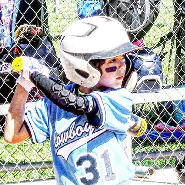 Youth baseball player with baseball and softball protective padded elbow sleeve