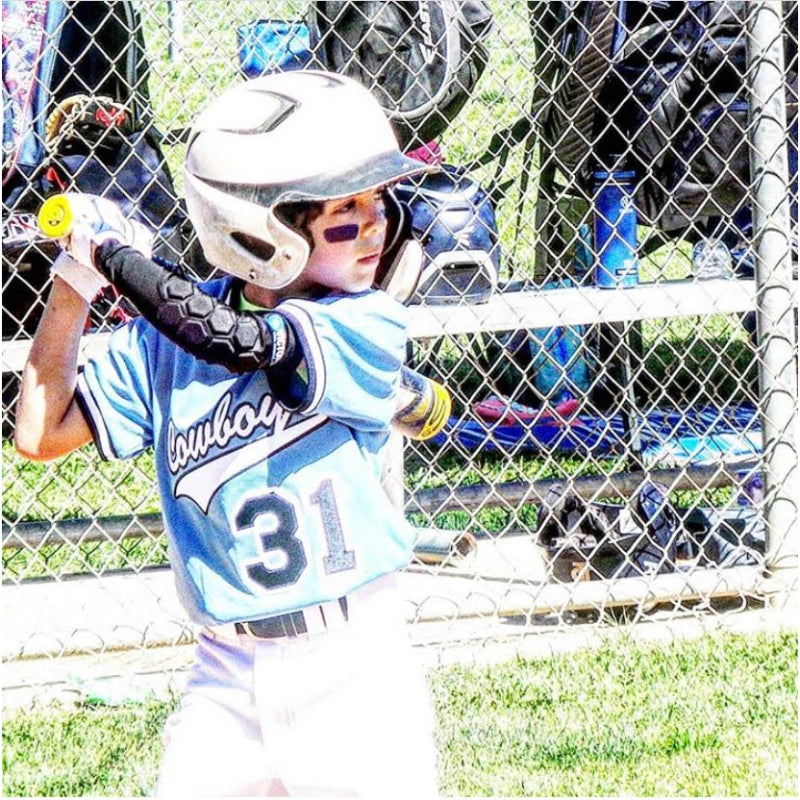 Youth baseball player wearing padded elbow sleeve